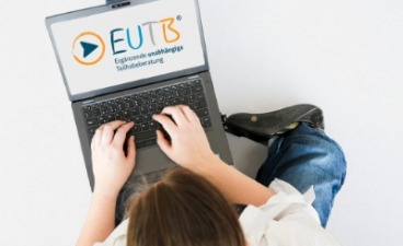 Informationssuche an einem Laptop durch eine Person mit Beinprothese Person, die einen Laptop nutzt. Die Person hat eine Beinprothese.